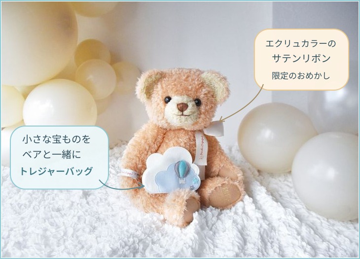 エクリュのサテンリボンとトレジャーバッグを身に着けたベア